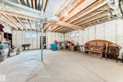 Unfinished basement featuring exposed wood joists, concrete flooring, and insulated walls - 