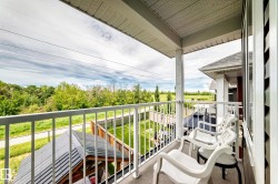 Upper-level balcony featuring white railings, a covered ceiling, and exterior siding - 