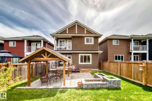 Backyard featuring a wooden gazebo with a paved patio, stone-faced raised garden beds, and a full privacy fence - 3895 Robins Crescent, Edmonton, AB 
