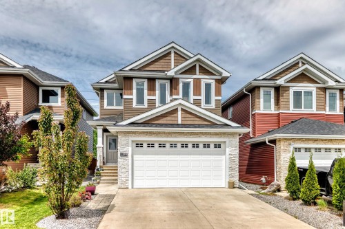 Two-story residence featuring a combination of brown siding, stacked stone accents, and white trim - 3895 Robins Crescent, Edmonton, AB 