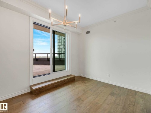 Light wood-finish flooring with crisp white baseboards and walls - 902 10108 125 Street, Edmonton, AB 