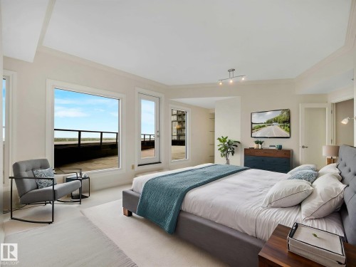 Bedroom featuring large windows, a glass-paneled door to an outdoor area, light-colored walls, and crown molding - 902 10108 125 Street, Edmonton, AB 