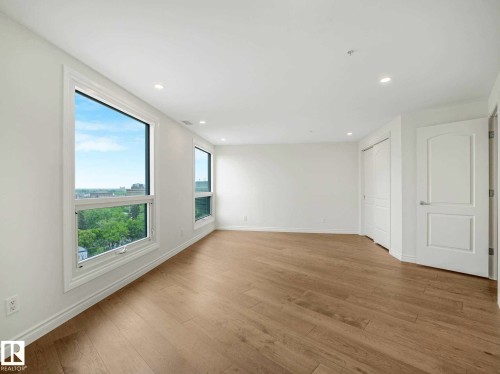 Bright interior space featuring light wood-finish flooring, white walls, and recessed lighting - 902 10108 125 Street, Edmonton, AB 