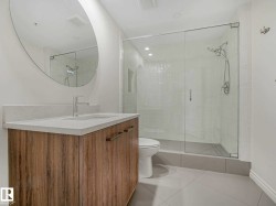 Modern vanity featuring wood-finish cabinetry, a light-toned countertop, and a sleek rectangular sink with a chrome faucet - 