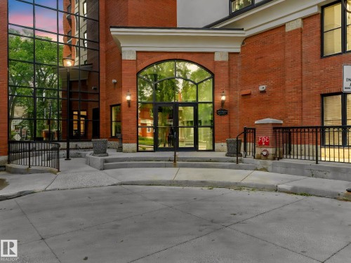 Brick exterior with expansive glass facade, featuring an arched entryway with double glass doors - 902 10108 125 Street, Edmonton, AB 