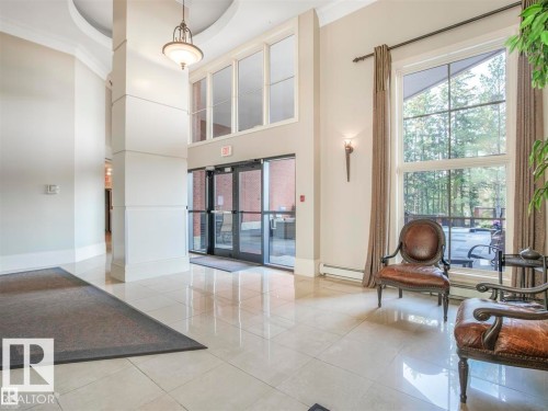 Building entrance featuring double glass doors, a two-story window array, and large format polished tile flooring - 902 10108 125 Street, Edmonton, AB 