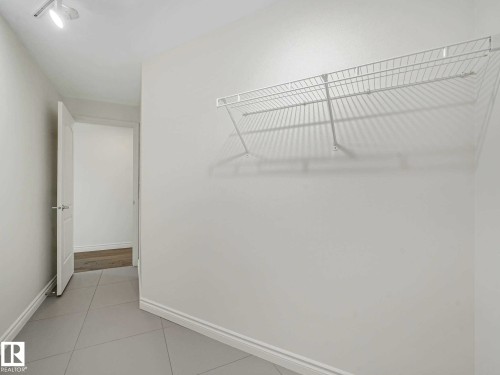 Utility space featuring a wire shelving unit, track lighting, and light gray tile flooring - 902 10108 125 Street, Edmonton, AB 