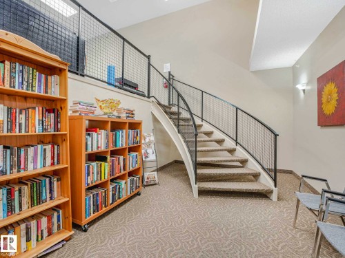 Curved staircase featuring carpeted treads and metal mesh railings - 902 10108 125 Street, Edmonton, AB 