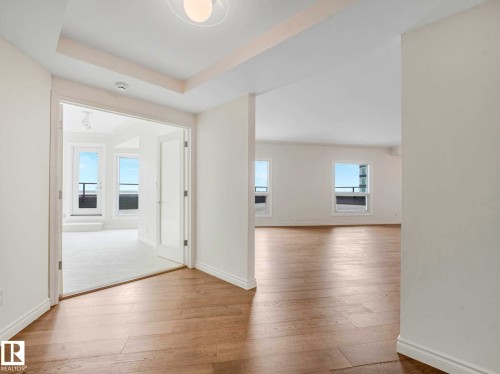 Light wood-finish flooring throughout, complemented by white baseboards and walls - 902 10108 125 Street, Edmonton, AB 
