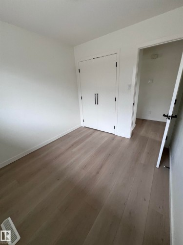 Light wood-finish flooring extending throughout the space - 11911 133 Avenue, Edmonton, AB 