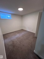 Carpeted room with white walls, a single window, and a flush-mount ceiling light - 