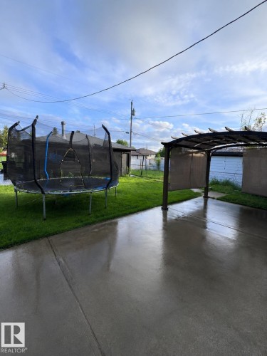 Expansive concrete patio area with a pergola structure - 11911 133 Avenue, Edmonton, AB 