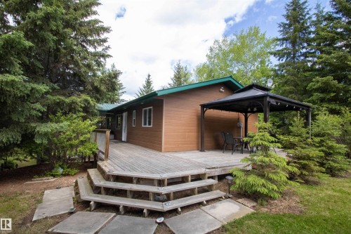 Expansive wood deck with multi-level steps, surrounded by mature trees - 104 60201 Rng Rd 122, Rural St. Paul County, AB 