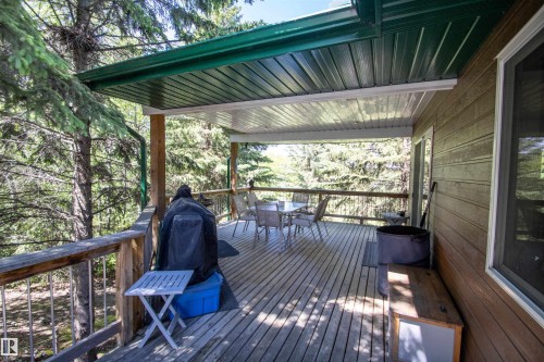 Covered wood deck with slatted wood railing and a green metal awning - 104 60201 Rng Rd 122, Rural St. Paul County, AB 