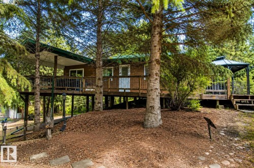 Elevated decking with a covered patio, wood siding, multiple windows, and a detached gazebo structure - 104 60201 Rng Rd 122, Rural St. Paul County, AB 