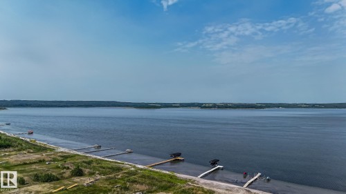 Waterfront property featuring multiple private docks and a shoreline bordered by natural vegetation - 104 60201 Rng Rd 122, Rural St. Paul County, AB 