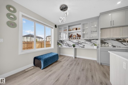 Contemporary kitchen featuring light wood-finish flooring and a large multi-pane window - 449 Roberts Cres, Leduc, AB 