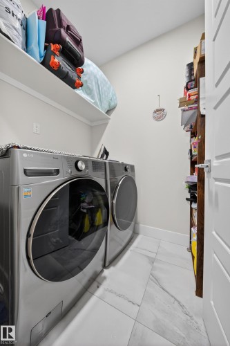 Laundry area featuring white walls, a white baseboard, and a white floating shelf - 449 Roberts Cres, Leduc, AB 
