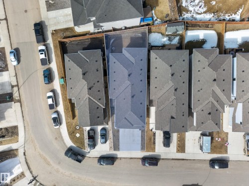 Aerial perspective showcasing a residential property with a dark grey shingled roof, a paved driveway, and a fenced backyard - 449 Roberts Cres, Leduc, AB 