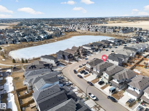 Aerial view showcasing the property situated on a curved street, featuring a grey shingle roof and light-colored siding - 449 Roberts Cres, Leduc, AB 