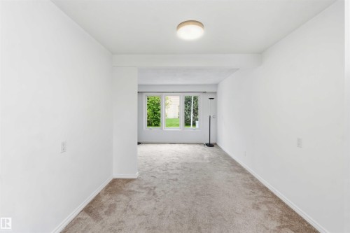 Bright interior space featuring light-colored carpet flooring and white painted walls - 17325 85 Avenue Nw, Edmonton, AB 