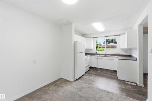 Kitchen area featuring white cabinetry, a single basin sink, and dark countertops - 17325 85 Avenue Nw, Edmonton, AB 