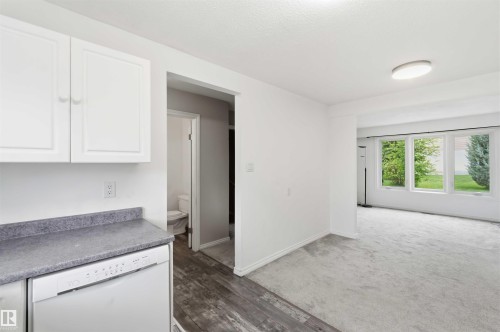 Kitchen area featuring white cabinetry, a white dishwasher, and gray countertop - 17325 85 Avenue Nw, Edmonton, AB 