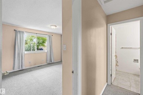 Carpeted interior room with a window, flush mount ceiling light, and light-toned walls - 17325 85 Avenue Nw, Edmonton, AB 