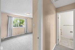Carpeted interior room with a window, flush mount ceiling light, and light-toned walls - 