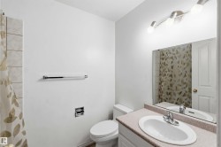 Bathroom featuring a white toilet, chrome towel bar, and a vanity with an integrated sink and laminate countertop - 