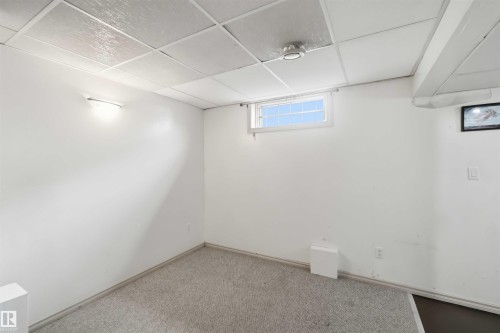 Carpeted room featuring white painted walls and a drop ceiling - 17325 85 Avenue Nw, Edmonton, AB 