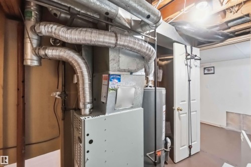 Utility room featuring a water heater, furnace, and exposed ceiling joists - 17325 85 Avenue Nw, Edmonton, AB 