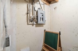 Electrical panel and exposed wiring on a textured wall - 