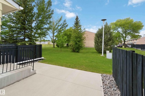Concrete patio area with black privacy fencing and gravel accent - 17325 85 Avenue Nw, Edmonton, AB 