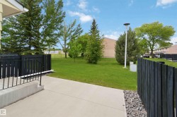 Concrete patio area with black privacy fencing and gravel accent - 