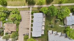 Overhead property rendering featuring a paved parking area and mature trees - 