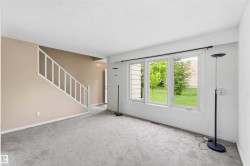 Living area featuring a three-panel window overlooking green landscaping - 