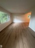 Spacious interior with wood-finish flooring, neutral wall tones, and recessed lighting - 9640 74 Avenue, Edmonton, AB 