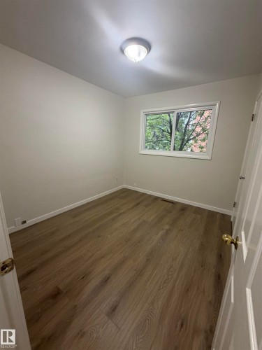 Wood-finish flooring throughout, complemented by light-toned wall finishes and white trim - 9640 74 Avenue, Edmonton, AB 