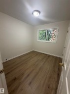 Wood-finish flooring throughout, complemented by light-toned wall finishes and white trim - 