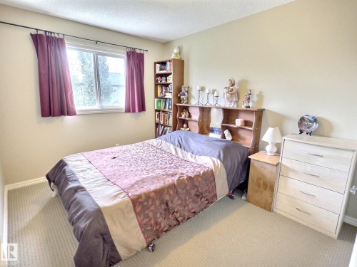 Bedroom featuring a window with natural light, wall-to-wall carpeting, and neutral-toned walls - 126 Calvert Wynd, Fort Saskatchewan, AB 