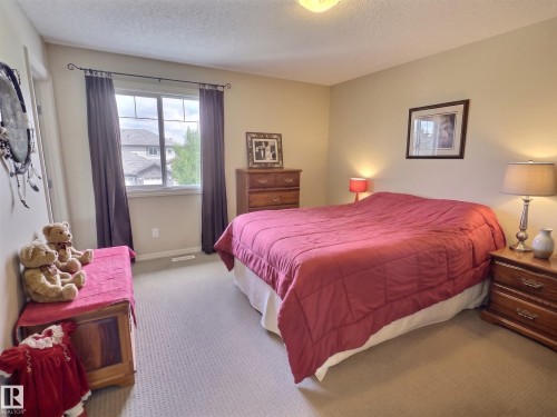 Carpeted bedroom with a large window and neutral wall tones - 126 Calvert Wynd, Fort Saskatchewan, AB 