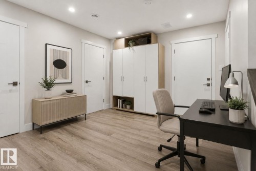 Versatile room featuring light wood-finish flooring, recessed lighting, and multiple white panel doors - 16 9250 156 Avenue, Edmonton, AB 