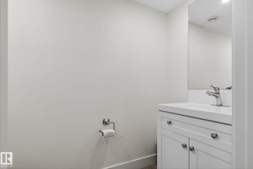 White vanity with chrome hardware, integrated sink, and wall-mounted mirror - 16 9250 156 Avenue, Edmonton, AB 