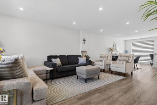 Bright living area featuring wood-finish flooring, recessed lighting, and a neutral color palette - 16 9250 156 Avenue, Edmonton, AB 