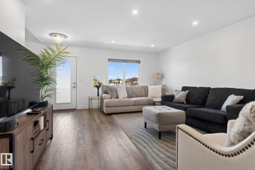 Open-concept living space with wood-finish flooring, recessed lighting, and white walls - 16 9250 156 Avenue, Edmonton, AB 