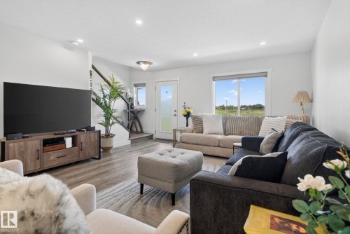 Open-concept living area featuring wood-finish flooring, recessed lighting, and a white-trimmed window - 16 9250 156 Avenue, Edmonton, AB 