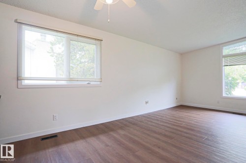 Open room featuring wood-finish flooring, white walls, and a ceiling fan - 10 Murray Crescent, St. Albert, AB 