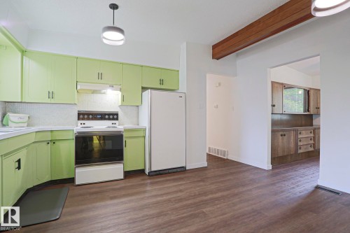 Kitchen featuring bright cabinetry, white countertops, tile backsplash, and wood-finish flooring - 10 Murray Crescent, St. Albert, AB 