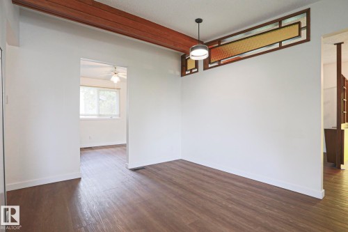 Open interior space featuring wood-finish flooring, white baseboards, and a modern ceiling fixture - 10 Murray Crescent, St. Albert, AB 